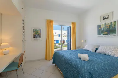 a bedroom with a bed and a desk and a window at TAC - Windmill OceanFront Villa in Albufeira