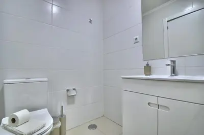 a white bathroom with a toilet and a sink at Old Town Gem by Atlantic Places in Albufeira