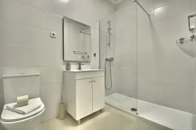 a white bathroom with a toilet and a shower at Old Town Gem by Atlantic Places in Albufeira