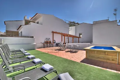 a patio with lawn chairs and a swimming pool at Old Town Gem by Atlantic Places in Albufeira