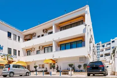 two cars parked in front of a building at Apartment Monaco mit Pool in Albufeira