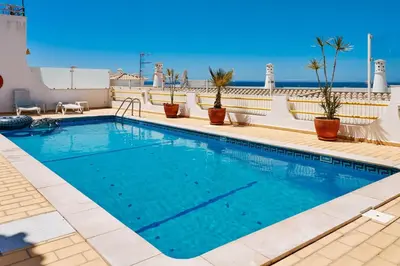 a swimming pool on top of a building with the ocean in the background at Apartment Monaco mit Pool in Albufeira
