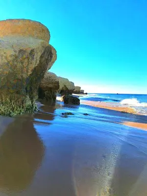 a beach with some rocks and the ocean at white T1 - Ocean View in Albufeira