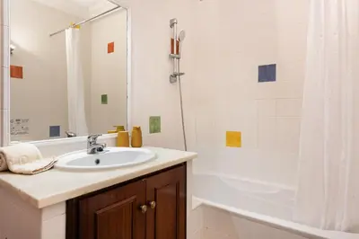 a white bathroom with a sink and a shower at Oasis apartment - City center by HD in Faro