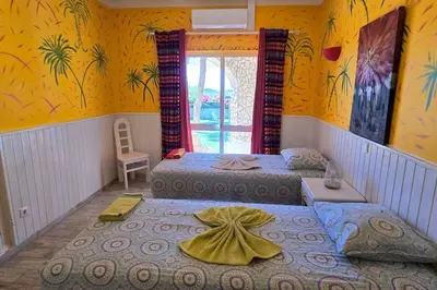 two beds in a room with yellow walls at Villa Ania - Private Villa with pool&Jacuzzi, 16 to 40 pax in Albufeira