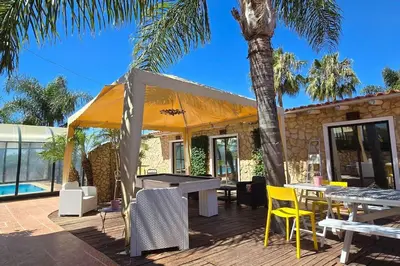 a patio with a tent and tables and chairs at Villa Ania - Private Villa with pool&Jacuzzi, 16 to 40 pax in Albufeira