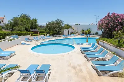 a pool with lounge chairs and a swimming pool at Sunshine Villa Salgados Guia Algarve in Albufeira