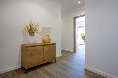 a hallway with a wooden dresser with a lamp on it at Krystal Bay Villa in Albufeira