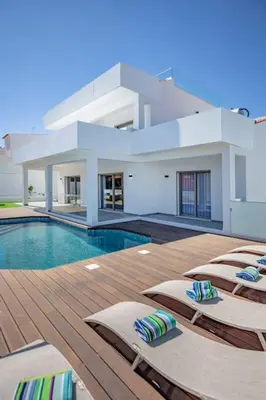 a pool with chaise lounges and a villa at Krystal Bay Villa in Albufeira