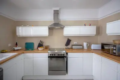 a kitchen with white cabinets and a stove at Villa Le petit charme in Albufeira