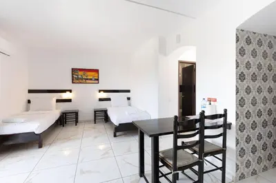 a room with a table and chairs and a bed at Magna Oura in Albufeira