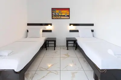 two beds in a room with two tables at Magna Oura in Albufeira