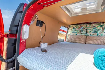 a table with plates of watermelon and a bottle of wine at Ocean Camper - Campervan & Surf rentals in Faro