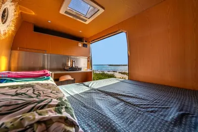 a door with a window with a view of the ocean at Ocean Camper - Campervan & Surf rentals in Faro