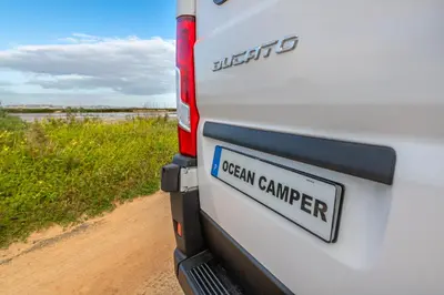 a license plate on the side of a truck on a dirt road at Ocean Camper - Campervan & Surf rentals in Faro
