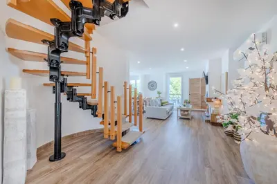 a living room with a spiral staircase in a house at 5 star Luxury SevenPines apartment with large balcony and 3 communal pool in Quarteira
