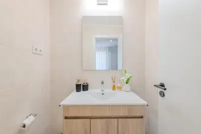 a white bathroom with a sink and a mirror at 5 star Luxury SevenPines apartment with large balcony and 3 communal pool in Quarteira