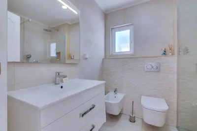 a white bathroom with a sink and a toilet at Villa Andorra, private pool next to golf in Vilamoura