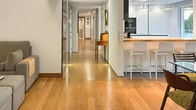 a living room with a couch and a kitchen at Refúgio Sereno Vilamoura T2 by HsR Vilamarina in Quarteira