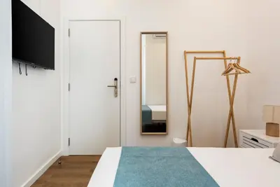 a bedroom with a bed and a mirror at Madalena Hostel e Suites in Faro