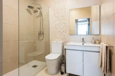 a bathroom with a toilet and a sink and a shower at Madalena Hostel e Suites in Faro