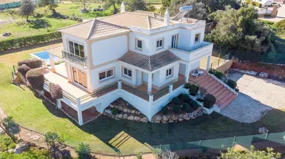 a large white house with a stone driveway at Villa Água in Albufeira