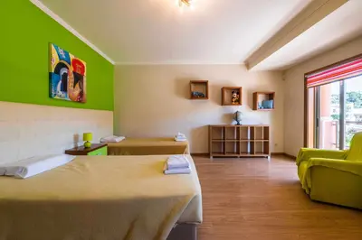a room with two beds and a green wall at Villa Hunês in Guia