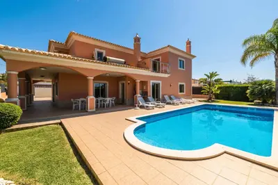 a villa with a swimming pool in front of a house at Villa Hunês in Guia