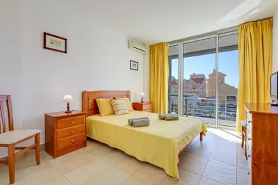 a bedroom with a bed and a large window at Apartment with 2 bedrooms at Vilamoura Marina in Quarteira