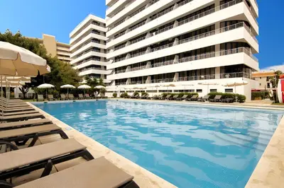 a swimming pool in front of a large building at Apartment with 2 bedrooms at Vilamoura Marina in Quarteira