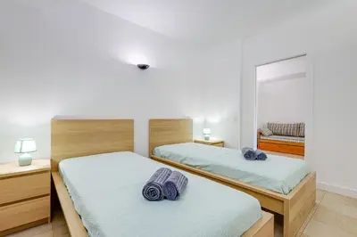 two beds in a bedroom with a mirror at Apartment with 2 bedrooms at Vilamoura Marina in Quarteira
