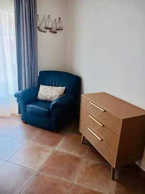 a blue couch and a dresser in a living room at Sunbliss - praia, piscina e localização central in Albufeira