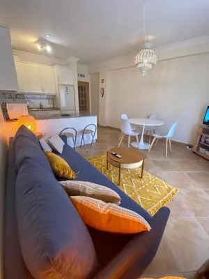 a living room with a blue couch and a table at Sunbliss - praia, piscina e localização central in Albufeira