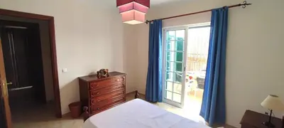 a bedroom with a bed and a window with blue curtains at Apt 3 Quartos, Terraço, Centro, Prestige For Home in Loulé