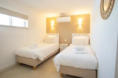 a bedroom with two beds with white sheets at Casa Quadra Dique in Faro