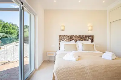 a bedroom with a bed and a sliding glass door at Casa Quadra Dique in Faro