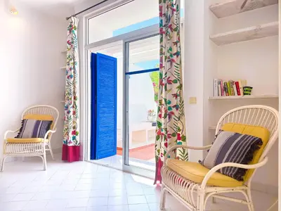a living room with two chairs and a sliding glass door at Ocean Breeze WindMill Condo by BeCherish in Albufeira