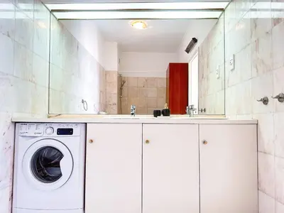 a washer and dryer in a white bathroom at Ocean Breeze WindMill Condo by BeCherish in Albufeira