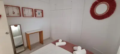a small white room with a bed and a mirror at T2 Falésia - Olhos de Água in Olhos de Água