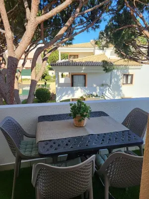 a table and chairs on a balcony with a house at T2 Falésia - Olhos de Água in Olhos de Água