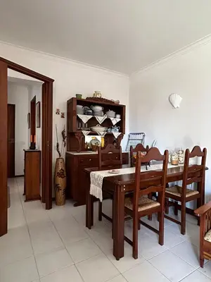 a dining room with a wooden table and chairs at Nice Flat in Quarteira Beach in Quarteira
