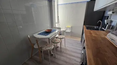 a small kitchen with a table and chairs in it at Nice Flat in Quarteira Beach in Quarteira