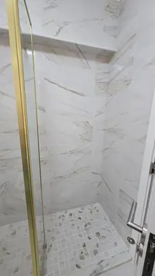 a shower with a glass door in a bathroom at Nice Flat in Quarteira Beach in Quarteira
