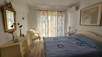 a bedroom with a blue bed and a dresser and a window at Nice Flat in Quarteira Beach in Quarteira