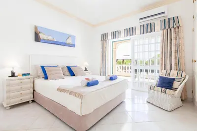 a white bedroom with a bed and a window at Villa Paloma by Algarve Vacation in Albufeira