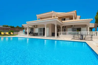 a villa with a swimming pool in front of a house at Villa Paloma by Algarve Vacation in Albufeira