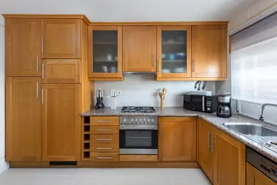 a kitchen with wooden cabinets and a stove top oven at Sea View Downtown - Albufeira in Albufeira