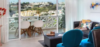 a living room with a balcony with a table and chairs at Sea View Downtown - Albufeira in Albufeira