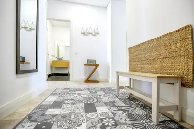 a hallway with a table and a rug at Nap in the shade Apartment in Faro