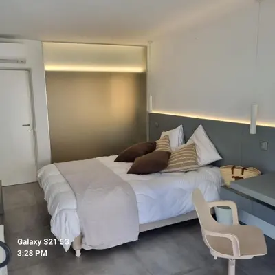 a bedroom with a large bed and a chair at Casa Mocha Vale do lobo 2 bed apartment in Loulé